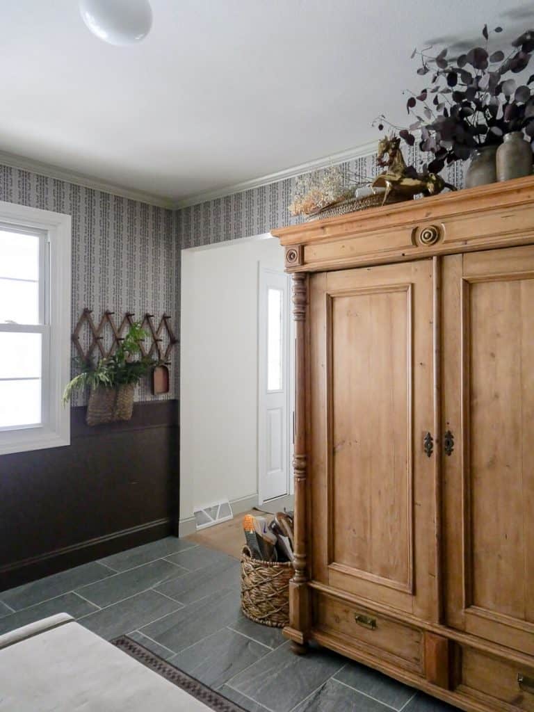 Dark brown paint color in a mudroom with antique cabinet.