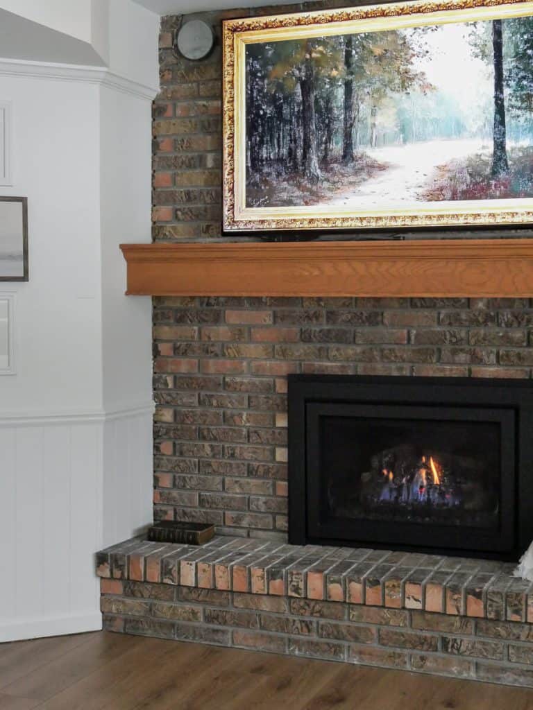 Brick fireplace with artwork.