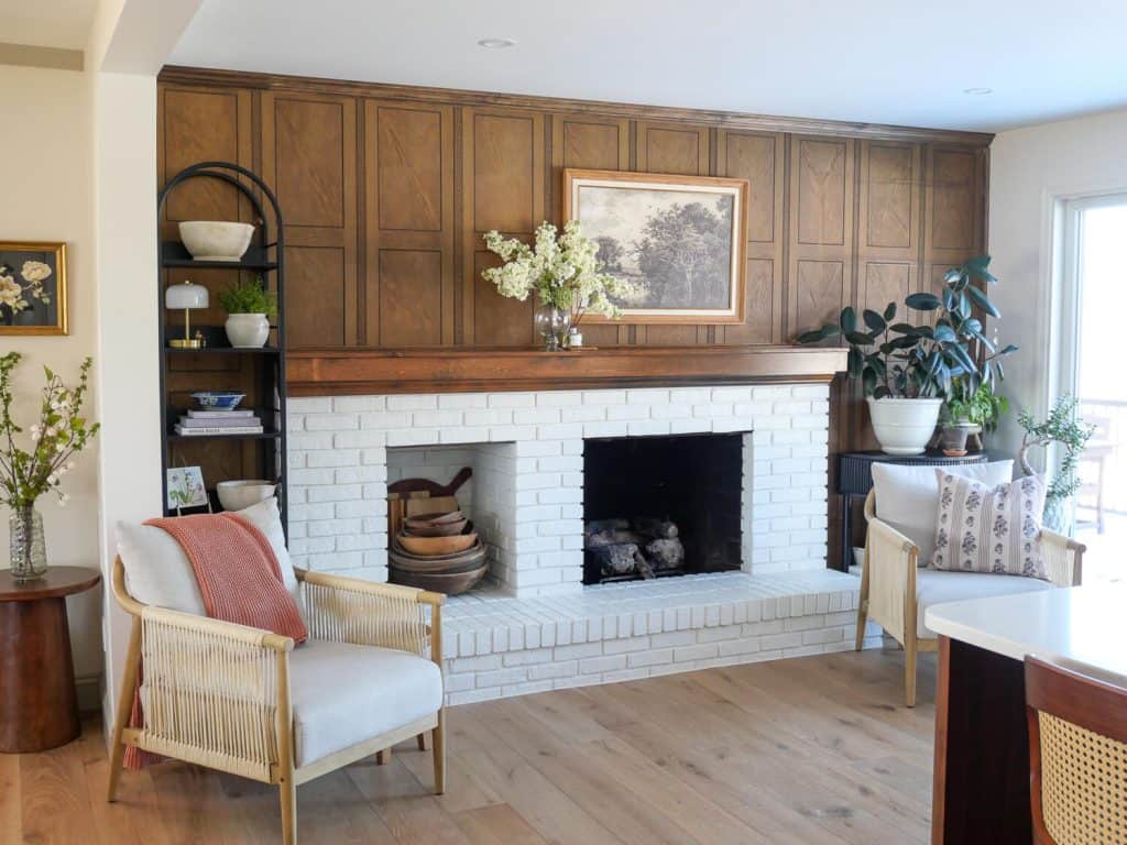Live plants next to a brick kitchen fireplace.