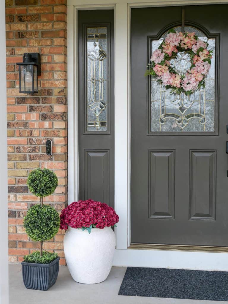 Close up of two tier boxwood topiary and plant pot.