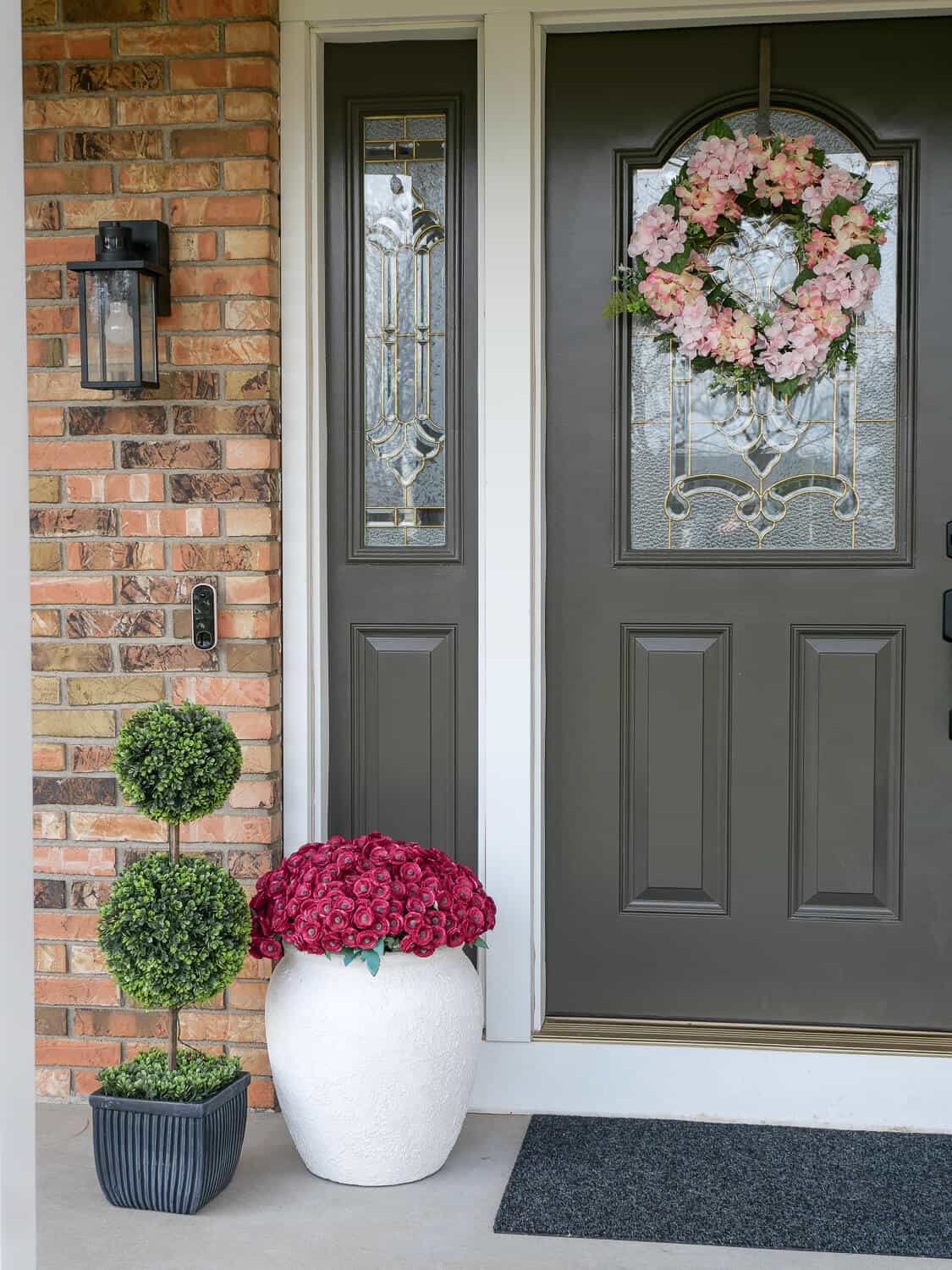 Close up of two tier boxwood topiary and plant pot.